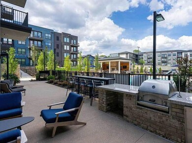View of patio with exterior kitchen, a balcony, and a grill