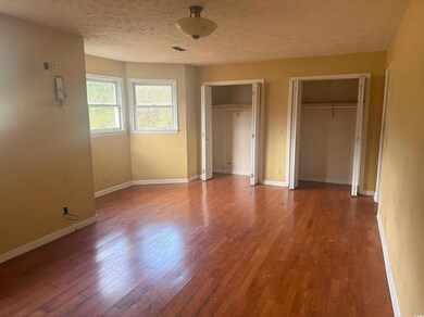 Unfurnished bedroom featuring baseboards, a textur