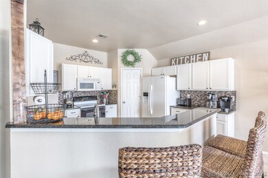 Granite, back splash and white cabinets along with