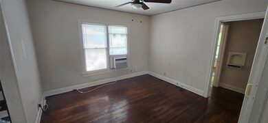 Empty room with ceiling fan, dark wood-style floo