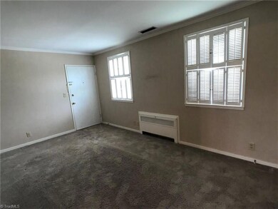 Large living room. Don't let the radiator on the wall fool you. This updated condo has a Heat Pump for central heating and air conditioning.