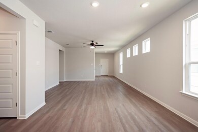 Unfurnished living room featuring ceiling fan, pl