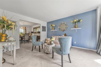 Living area featuring carpet flooring and a chandelier