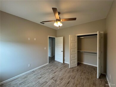 Unfurnished bedroom with wood finished floors, a closet, baseboards, and ceiling fan