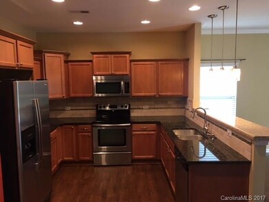 Kitchen with granite counter tops and stainless appliaces plus serving bar.