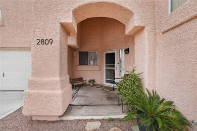 Property entrance featuring a garage and stucco si