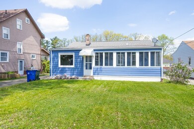 View of front of house with a sunroom and a front lawn