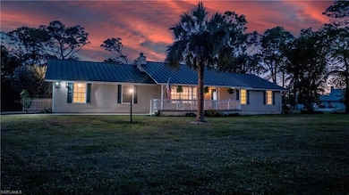 View of front of home featuring metal roof, a standing seam roof, and a front lawn