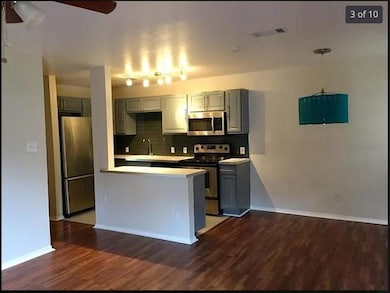 Kitchen with dark wood-style flooring, light coun