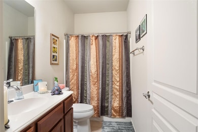 Guest bathroom featuring toilet, a shower with cur