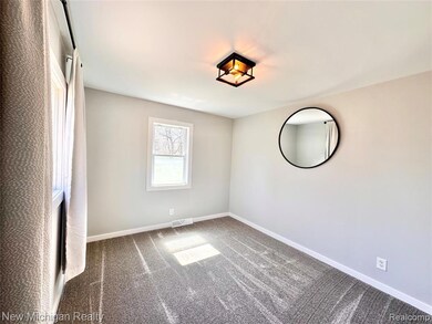 Carpeted spare room featuring baseboards