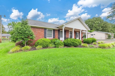 View of front of house featuring brick siding and covered porch