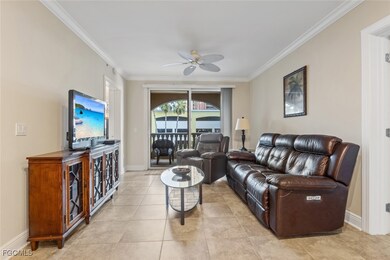 Living room featuring ornamental molding, a ceiling fan, and light tile patterned flooring