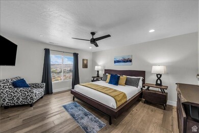 Bedroom featuring wood finished floors, a ceiling fan, a textured ceiling, and recessed lighting