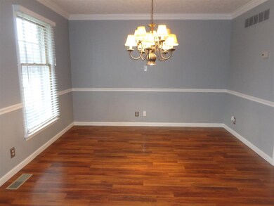 Formal Dining room has chair rail and wood floor.