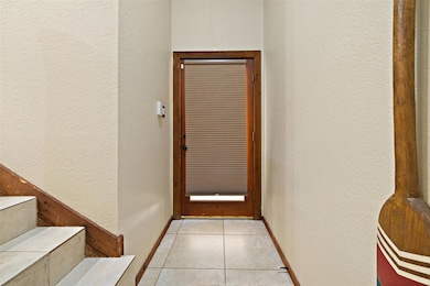 Doorway featuring a textured wall, tile patterned