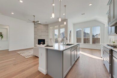 Kitchen with gray cabinetry, ceiling fan, hanging 