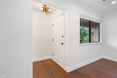 Entrance Foyer featuring new light fixture, new blinds, dark wood-style floors, and new ornamental molding.