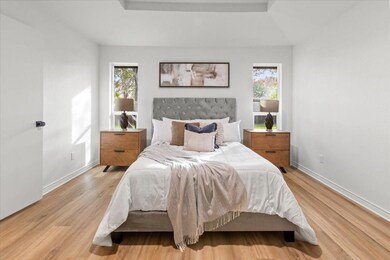 Bedroom with light  flooring and multiple windows