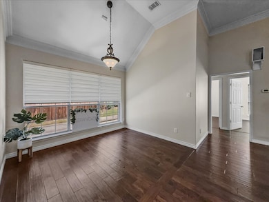 Spare room featuring crown molding, high vaulted ceiling, and dark wood-style floors