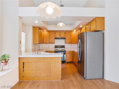 Kitchen with range with gas cooktop, a raised ceil