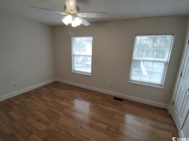 Unfurnished room with a ceiling fan, wood finished