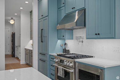 Kitchen with professional grade stainless steel appliances, pot filler, bill 10 bottom amount refrigerator, and backsplash