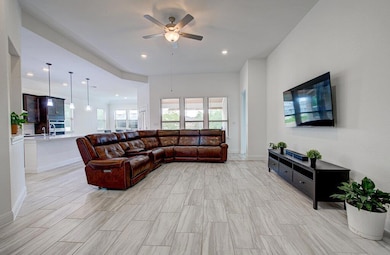 Living area featuring ceiling fan and recessed li