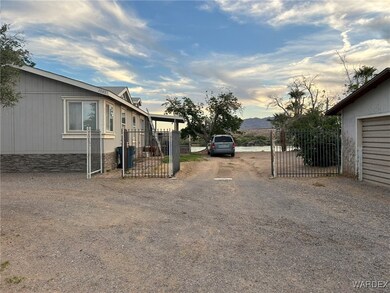 View of yard with fence, driveway, and a gate