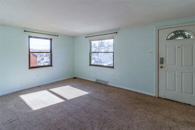 Enter front door to living room with neutral carpe
