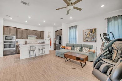 Living room featuring a ceiling fan, recessed lig