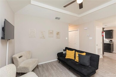 Living area featuring baseboards, visible vents, light wood-style floors, and a ceiling fan