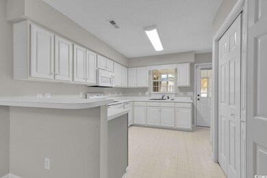 Kitchen with white appliances, sink, kitchen penin