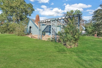 Back of property featuring a yard and a pergola