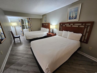 Bedroom with a textured ceiling, baseboards, and d
