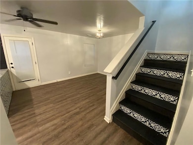 Stairs featuring wood finished floors and ceiling fan
