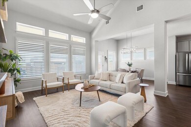 Living room featuring a chandelier, a ceiling fan