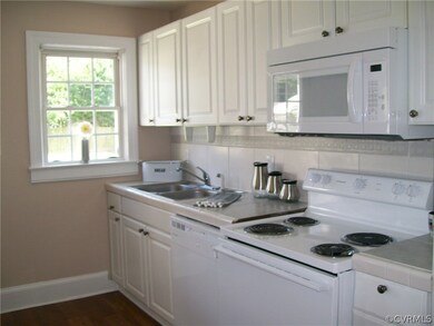 Tile counter tops and vinyl flooring. Very bright kitchen with lots on natural light!!