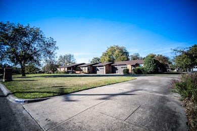 Single story home with concrete driveway, a front yard, and an attached garage