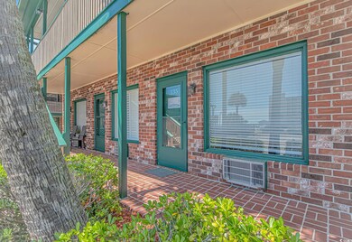 Doorway to property with covered porch and brick s