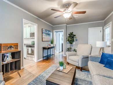 Living area with a ceiling fan, light wood-style f