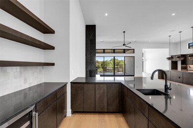 Kitchen with a sink, open shelves, open floor pla
