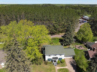 Aerial view of property and surrounding area with a forest