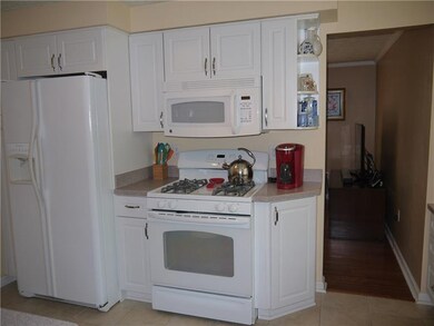 Kitchen showcases white cabinets and appliances.