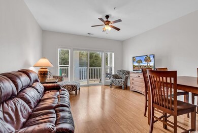 Living room featuring light wood-type flooring and a ceiling fan