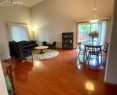 Living room featuring wood finished floors & high vaulted ceiling