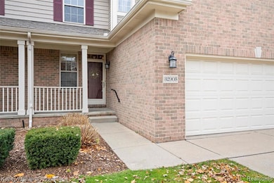 View of exterior entry featuring brick siding and a porch