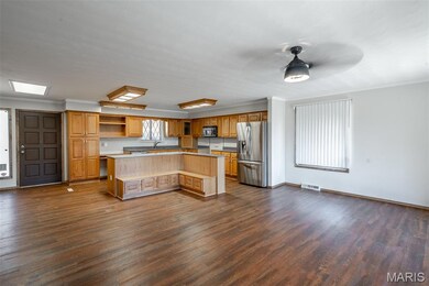 Kitchen featuring ornamental molding, open shelves, appliances with stainless steel finishes, open floor plan, and light countertops
