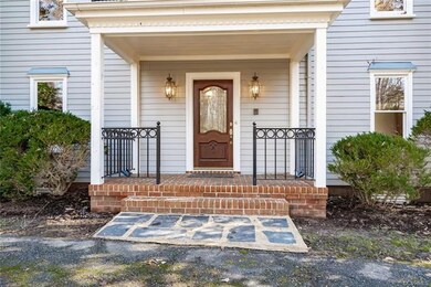 Covered front porch with metal railings, brick sto