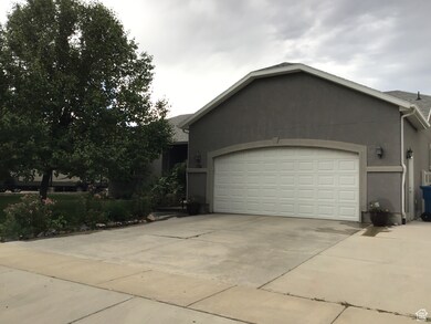 View of side of property featuring a garage, concrete driveway, and stucco siding